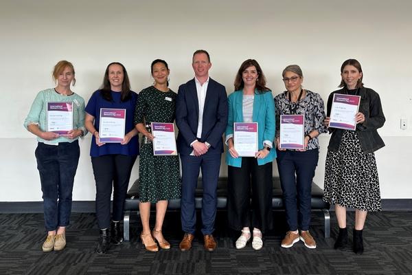 Six of our 2023 Inspirational Women award recipients holding their certificates with Chief Operating Officer/Deputy CEO Cameron Goodyear.
